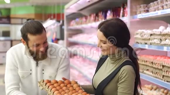 年轻的家庭在杂货店买鸡蛋慢动作肖像视频的预览图