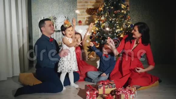 幸福的家庭有五个人他们都在微笑看着圣诞树脚下的摄像机视频的预览图