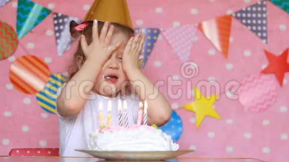 一个小女孩吹灭生日蛋糕上的蜡烛用手指吃宝贝许愿视频的预览图
