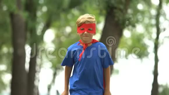 超级英雄男孩在公园玩耍假装飞翔勇敢的孩子和胜利者的概念视频的预览图