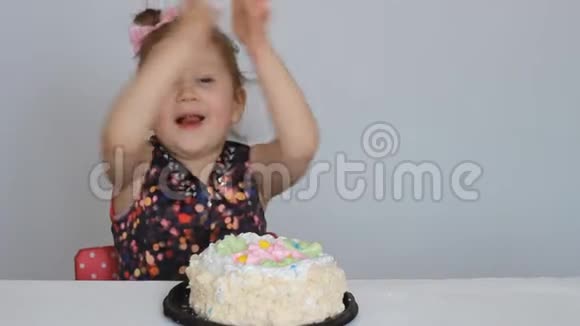 生日快乐一个可爱的女孩微笑高兴鼓掌吃蛋糕舔她的手指视频的预览图