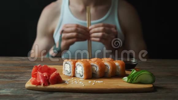 一位年轻的帅哥正在日本餐馆用筷子吃寿司卷视频的预览图