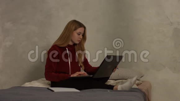 卧室里有笔记本电脑的可爱女学生视频的预览图
