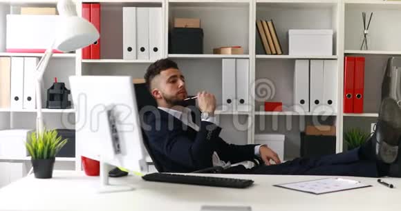 年轻的商人在办公室工作腿在桌子上视频的预览图