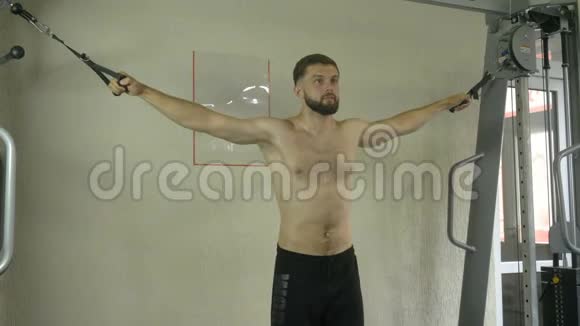 一个身体赤裸的年轻人在健身房锻炼身体在帮助下锻炼手部肌肉视频的预览图