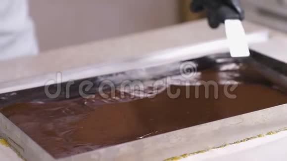 液体巧克力是用金属刮刀在烤盘上滚出来的视频的预览图