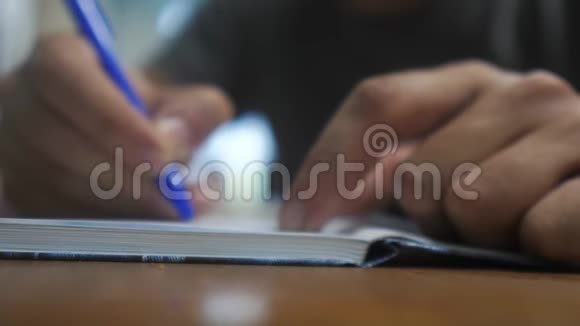 人在笔记本上写字男人用生活方式记事本手写概念商业教育1男人在房间里做笔记视频的预览图