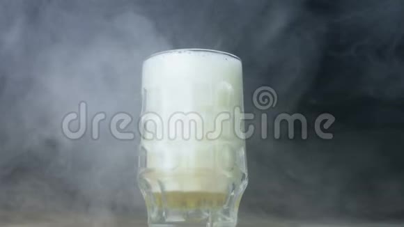 一杯皮尔或啤酒缓慢地旋转并在烟雾中停留视频的预览图