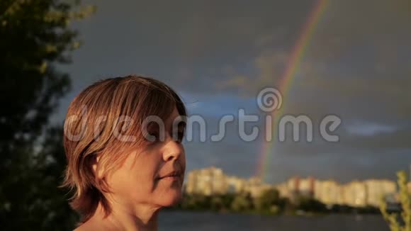 在彩虹和多云天气期间女人接电话视频的预览图