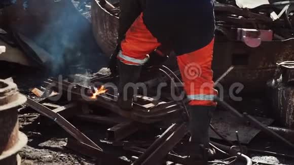 工人在废料堆上用煤气切割机切割生锈的金属视频的预览图