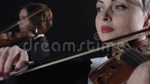 女孩们在房间里演奏小提琴黑色背景关门视频的预览图