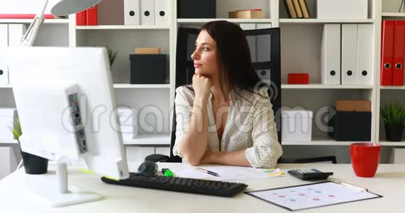 女商人坐在办公室的椅子上望着远处视频的预览图