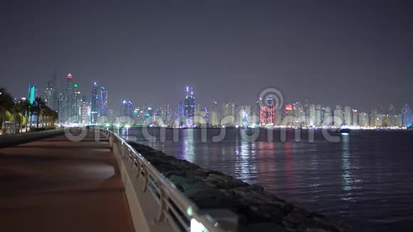 迪拜的夜晚城市灯光夜间JBR或朱美拉海滩住宅或迪拜码头从海上或棕榈岛到JBR码头的景观视频的预览图