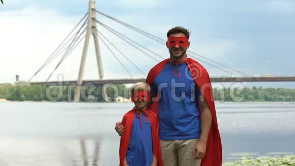 穿着超级英雄服装的父亲和儿子竖起大拇指充满动力和团队合作视频的预览图