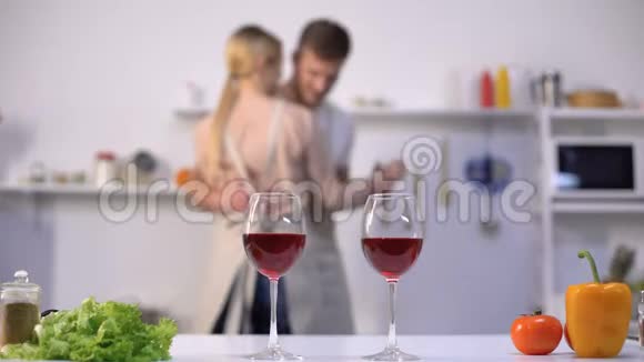 餐桌上的酒杯背景上跳舞的家庭情侣厨房内部视频的预览图