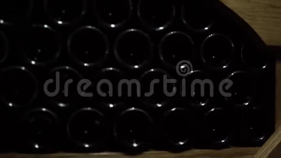 酒窖里一堆酒瓶的特写镜头存放在石头木架中的玻璃瓶红酒视频的预览图