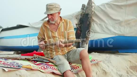 老人坐着挑选竹编制作手工长笛视频的预览图
