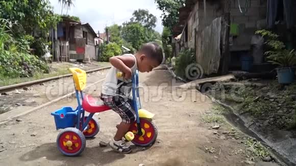 小男孩沿着铁轨骑着小三轮车视频的预览图