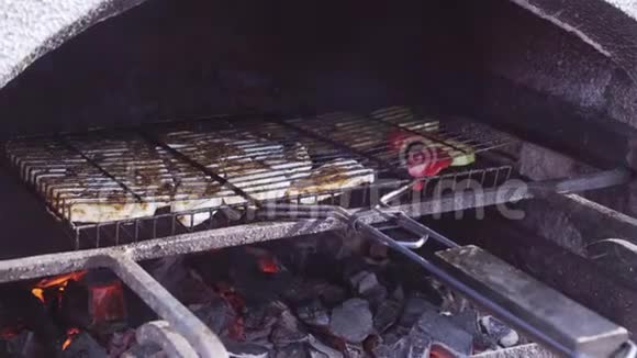 烤架上的肉和蔬菜放在砖烤箱里视频的预览图