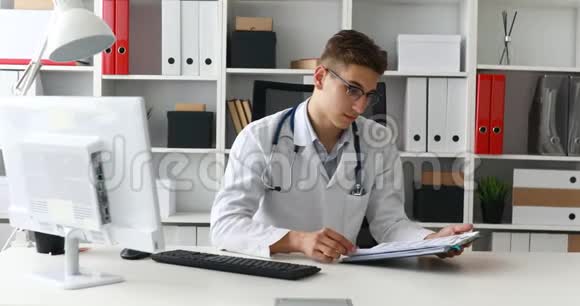 年轻医生拿着文件摘下眼镜视频的预览图