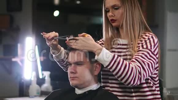 女理发师在美容店剪发微笑男客户视频的预览图