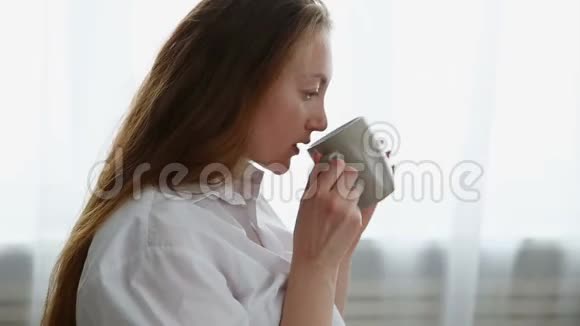 穿着白色衬衫女人在家喝咖啡视频的预览图