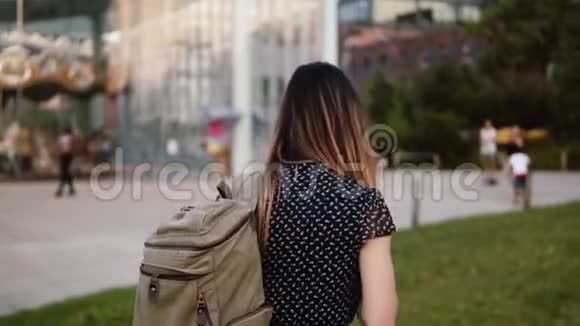 快乐的年轻白种人女性旅行者带着墨镜背包探索阳光明媚的布鲁克林公园慢镜头拍照视频的预览图