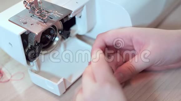 一个裁缝的手正在为缝纫机准备一个筒管慢动作视频的预览图