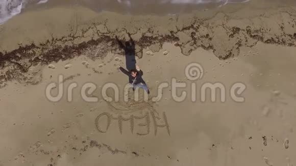 在海滩上打招呼的女孩用无人机拍摄视频的预览图