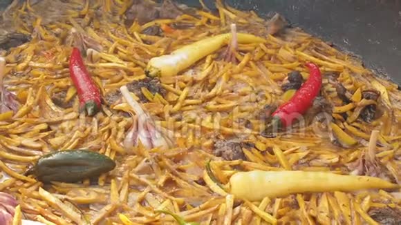乌孜别克国菜皮拉夫在一个大铸铁大锅上放火切黄胡萝卜加入巴宝莉全是视频的预览图