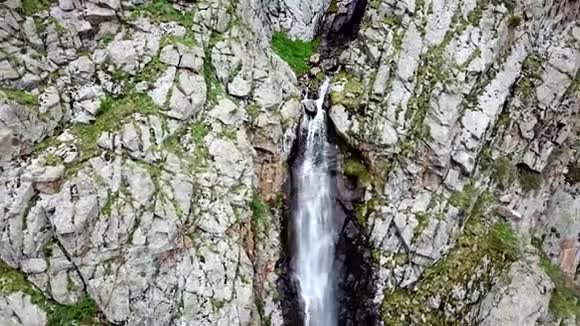 瀑布鸟瞰岩石绿草和绿色植物之间的瀑布视频的预览图