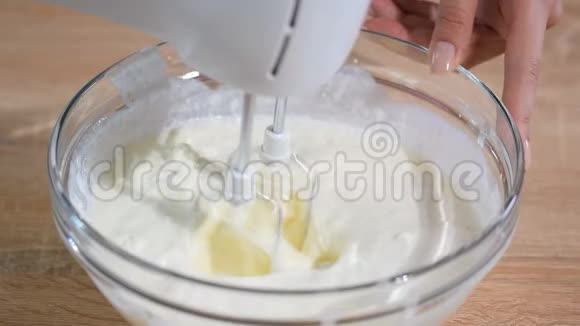将白色奶油与马达搅拌器混合在碗中烘焙原料烤蛋糕视频的预览图