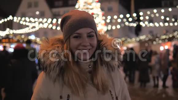 幸福的微笑女人站在圣诞市场与美丽的照明视频的预览图
