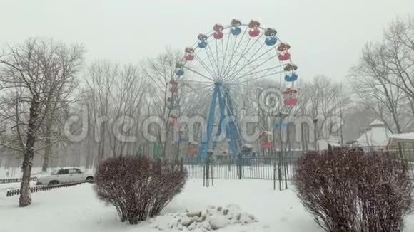 城市大雪公园里在阴暗的一个空旷的游乐园里看到白雪覆盖的摩天轮视频的预览图
