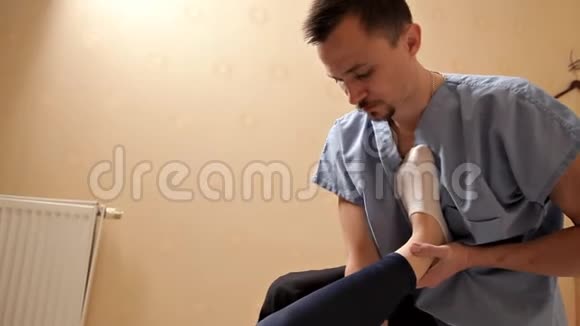男性理疗师在理疗室按摩病人的腿治疗按摩康复视频的预览图