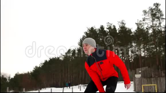 有魅力的运动健将在冬季和雪天的户外健身中进行水壶钟运动视频的预览图