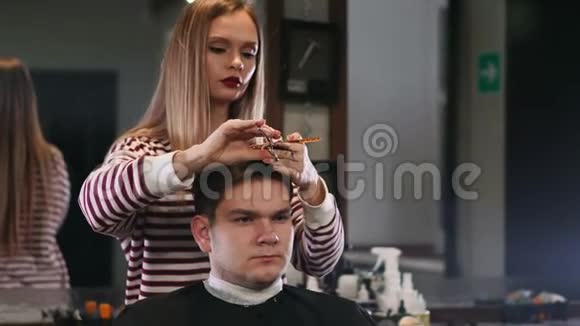 女理发师在美容店剪发微笑男客户视频的预览图