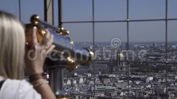 女人用硬币望远镜观察城市视频的预览图