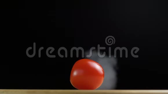 刀把红色的小番茄或樱桃番茄在烟雾和慢动作中切成两半视频的预览图