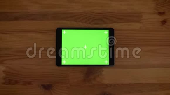 快速缩放水平平板电脑的顶部镜头与绿色屏幕上的木制桌子背景视频的预览图
