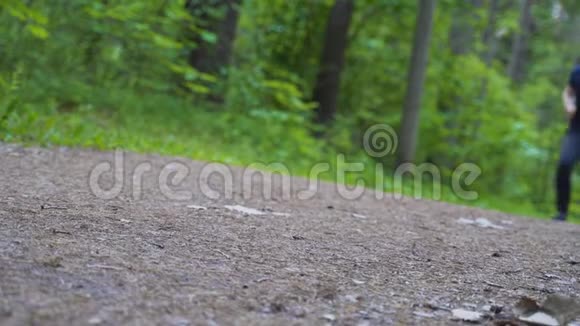 人沿着森林里的小路跑摄像机从下面拍摄视频的预览图