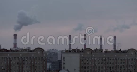 吸烟烟囱城市屋顶和一架飞行飞机视频的预览图