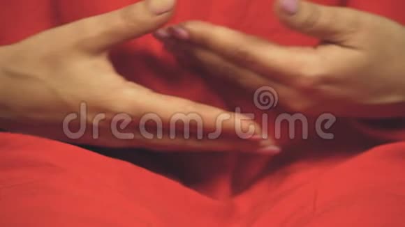 穿着五颜六色红色长袍的女佛教徒准备冥想双手交叉视频的预览图