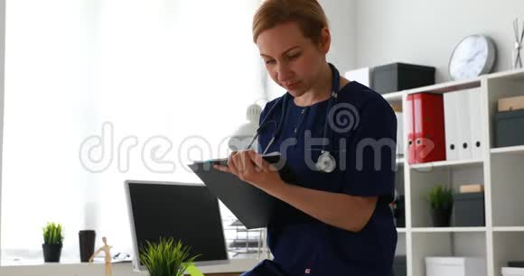 坐在窗口对面桌子上的医生填纸的歪歪斜斜的图像视频的预览图