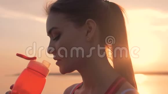 在阳光下喝水的时候靠近一个漂亮女人的脸视频的预览图