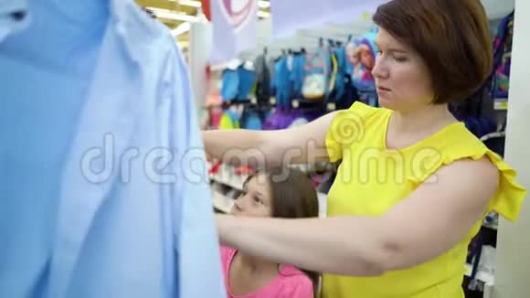 白人母女在商店货架旁选择市场上的衬衫视频的预览图