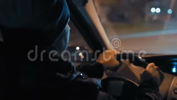 近景男子驾驶汽车穿越夜城的后景视频的预览图