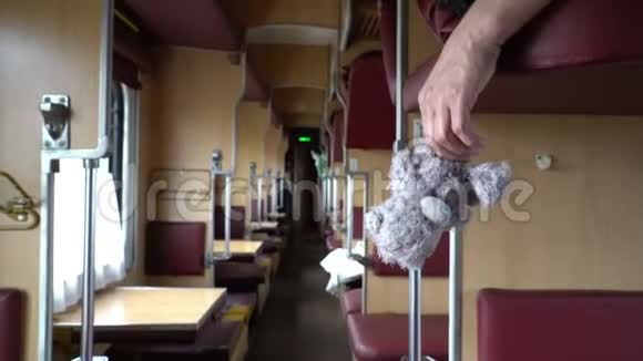 乘火车旅行时雄性手拿着玩具熊在发抖视频的预览图