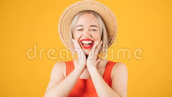 可爱的微笑金发女人戴着黄色背景的草帽积极的快乐情绪停止播放录像视频的预览图