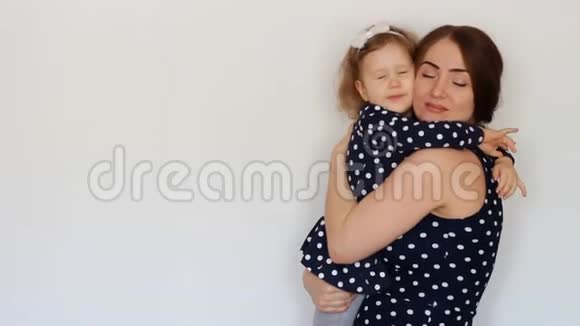 一个幸福的母亲抱着一个女儿拥抱一个年轻的女人和她的孩子闭着眼睛做梦梦想视频的预览图